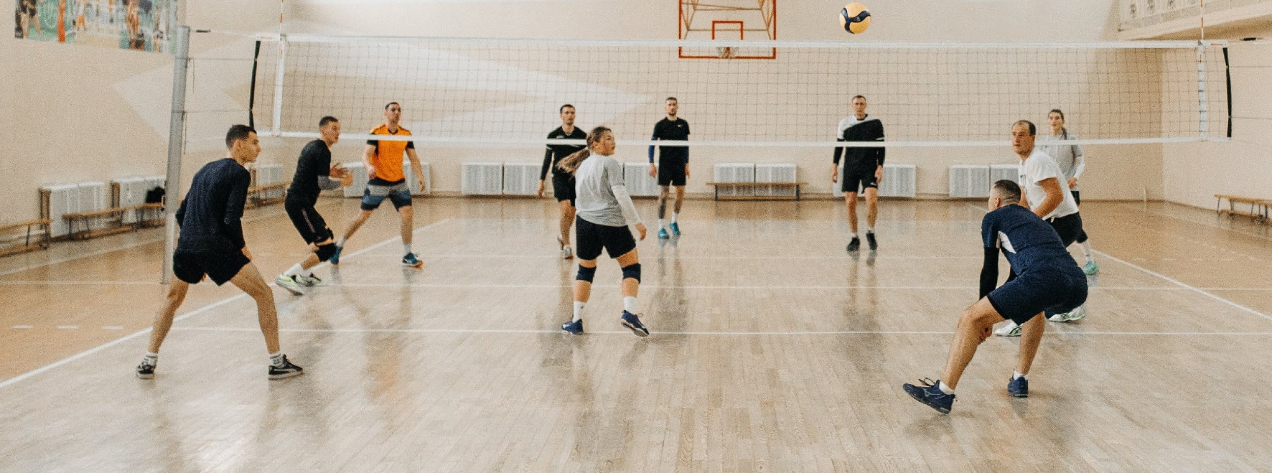 Un groupe de personne joue au volley en salle intérieur